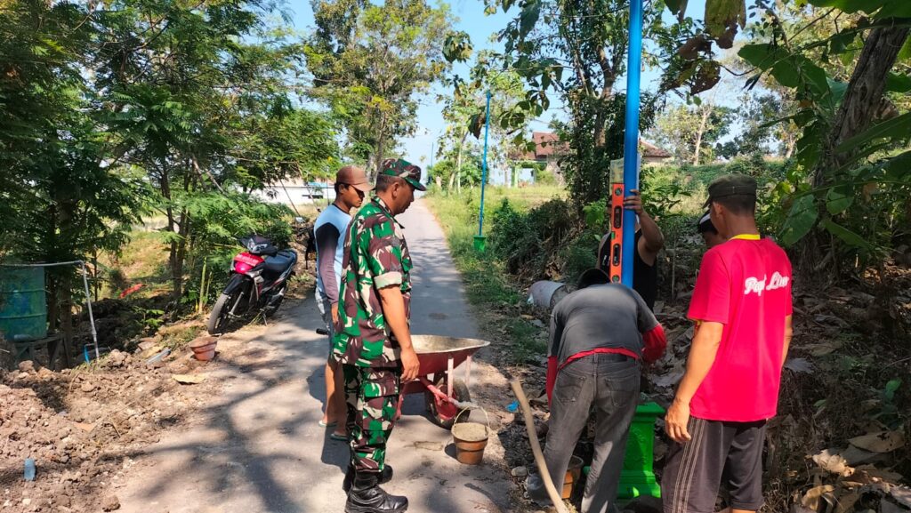 Babinsa Desa Prambon Laksanakan Karya Bhakti Pemasangan Lampu Jalan untuk Keamanan Wilayah