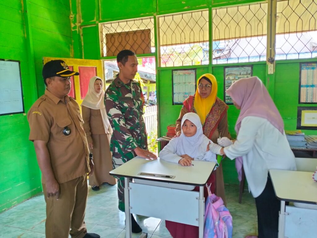 Babinsa Aluh – Aluh Sukseskan Program Imunisasi Dan Pemberian Obat Cacing Anak Sekolah