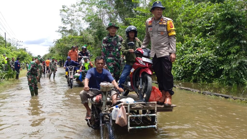 Seragam Loreng Basah Kuyup, Dandim 0105/Abar Hilir Mudik Trabas Banjir Bantu Warga Seberangkan Kendaraan