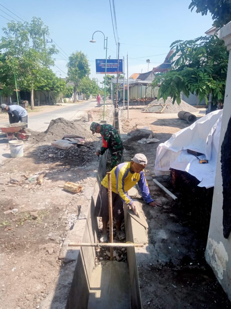 Babinsa dan Warga Bahu membahu Kerja Bakti Perbaiki Saluran Air di Desa Ngale.