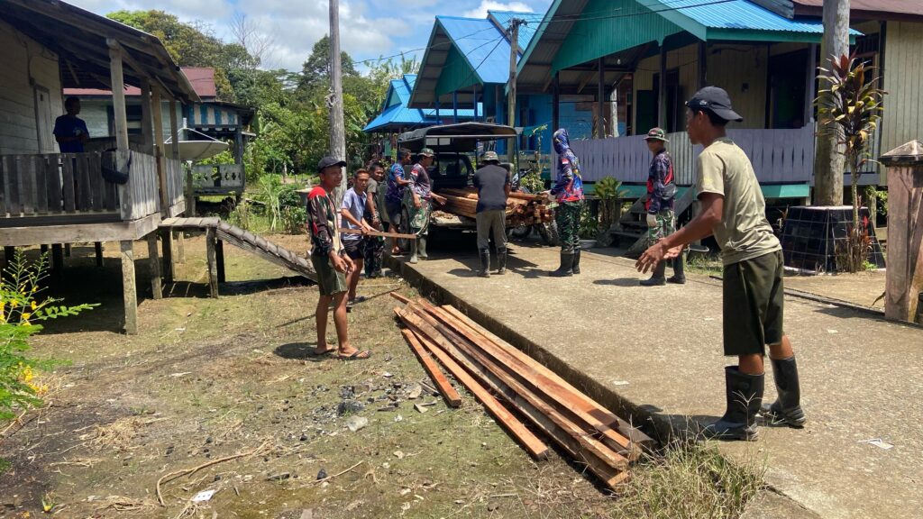 Kompak, Anggota Satgas TMMD Bersama Warga Angkut Material Kayu Ke Lokasi Sasaran RTLH