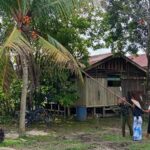 Anggota Satgas TMMD Bantu Warga Mengambil Buah Kelapa di Kebun